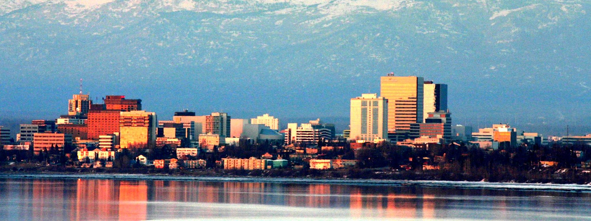 Downtown Anchorage on an April evening, with snow-covered mountains behind