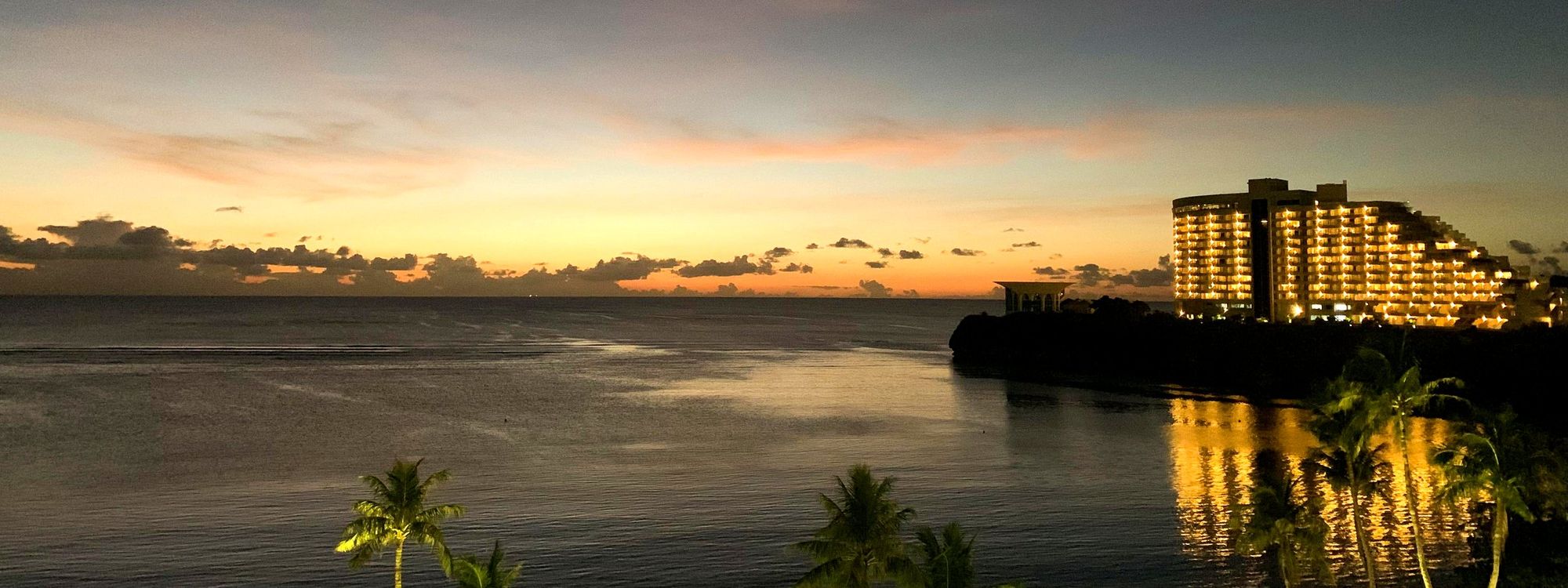 Tumon Bay, Guam in the evening after sunset, with a lit hotel on the point