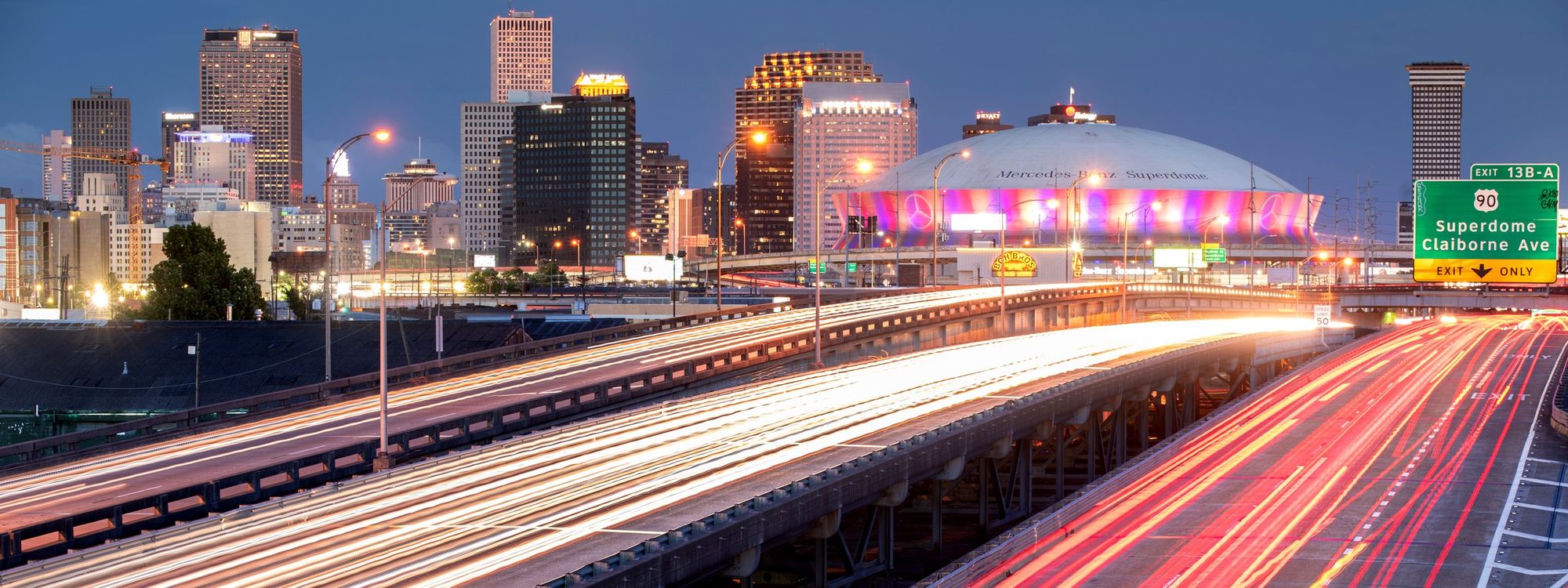 New Orleans skyline at dusk with light trails on Interstate 10
